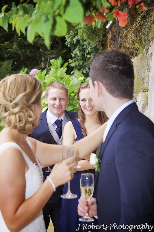 Best man and bridesmaid smiling at the couple in the distance - wedding photography sydney